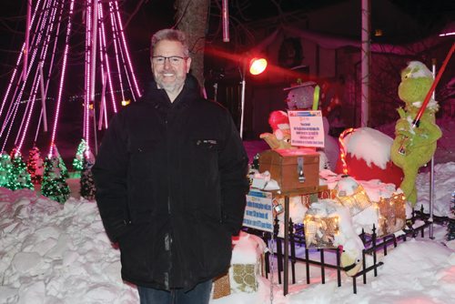 Canstar Community News Michael Geiger-Wolf, 52, stands next to the donation box for the Canadian Cancer Societyon his front yard that is filled with over 200,000 lights. /Photo by Christina Hryniuk
