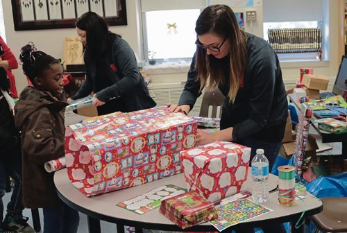 Canstar Community News Volunteer Krista Gagne (right), from Think Shift, wraps Therese Mwarabu (left) gift for her mother at Make Nice Happen on Dec. 15, 2016.