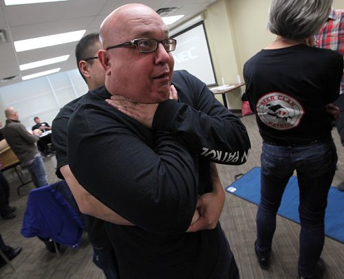 PHIL HOSSACK / WINNIPEG FREE PRESS -  Bear Clan's Dan Gordon mimicks choking as Sam Lavalee sets up behind him to remove an obstruction from his airway Monday as members of the North End's Bear Clan Patrol upped their game with first aid training with Paramedics from the MGEU Local 911 to teach them CPR and basic first aid. See story.  - December 19, 2016