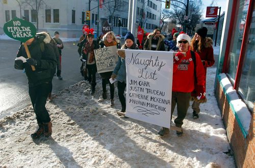 BORIS MINKEVICH / WINNIPEG FREE PRESS
A group of concerned citizens protest the recent approval of Kinder Morgan and Line 3 pipelines in front of MP for Winnipeg South Centre and Minister of Natural Resources Jim Carr's office at 611 Corydon. They sang Christmas carols with the words changed to reflect their protest message. Here they march towards Carr's office on the same block. Dec. 22, 2016