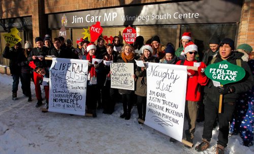 BORIS MINKEVICH / WINNIPEG FREE PRESS
A group of concerned citizens protest the recent approval of Kinder Morgan and Line 3 pipelines in front of MP for Winnipeg South Centre and Minister of Natural Resources Jim Carr's office at 611 Corydon. They sang Christmas carols with the words changed to reflect their protest message. Dec. 22, 2016