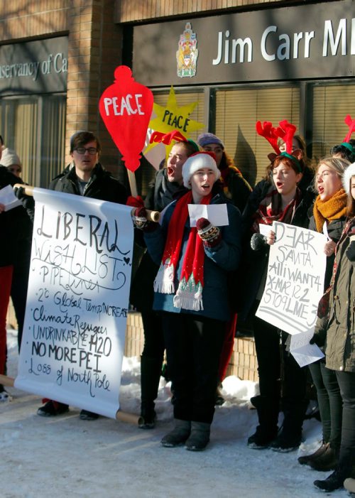 BORIS MINKEVICH / WINNIPEG FREE PRESS
A group of concerned citizens protest the recent approval of Kinder Morgan and Line 3 pipelines in front of MP for Winnipeg South Centre and Minister of Natural Resources Jim Carr's office at 611 Corydon. They sang Christmas carols with the words changed to reflect their protest message. Dec. 22, 2016