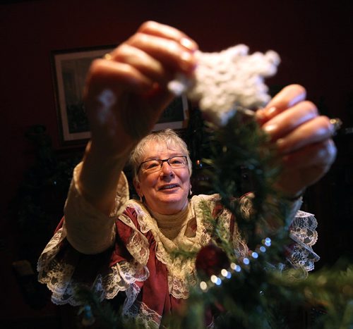 PHIL HOSSACK / WINNIPEG FREE PRESS -   Calla Lofvendahl pins a hand knot star on top of a small Christmas Tree in the den at Dalnavert House Thursday. See Bill Redekop story. - December 20, 2016