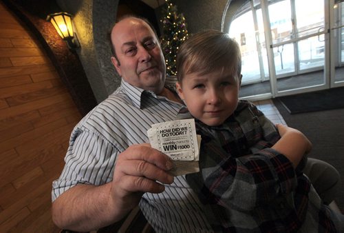 PHIL HOSSACK / WINNIPEG FREE PRESS -  Ray McKee poses with hios receipt from WalMart and Hunter Falinski on his lap. Ray bought a pair of McDonald's gift cards for Hunter and his mom Tanya Falinski from WalMart who forgot to activate them.  Neither corperation has been helpful See Courtney Bannatyne story.  - December 23, 2016