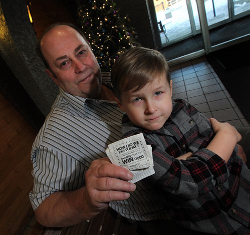 PHIL HOSSACK / WINNIPEG FREE PRESS -  Ray McKee poses with hios receipt from WalMart and Hunter Falinski on his lap. Ray bought a pair of McDonald's gift cards for Hunter and his mom Tanya Falinski from WalMart who forgot to activate them.  Neither corperation has been helpful See Courtney Bannatyne story.  - December 23, 2016