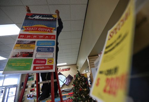 TREVOR HAGAN / WINNIPEG FREE PRESS
Reg Bergmann hangs banners advertising Advance's boxing week sales known as the Krazy Karnival, Saturday, December 24, 2016.