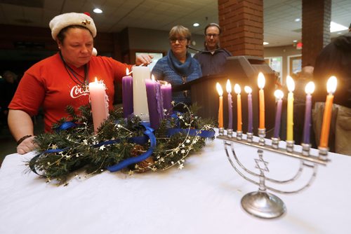 JOHN WOODS / WINNIPEG FREE PRESS
Dolores Chodachek lights a Advent Wreath, as Lynda Trono, Community Minister and Rabbi Alan Green look on, during a Christmas/Hanukah Feast which was hosted by Shaarey Zedek Synagogue and West Broadway Community Ministry at Crossways in Common Sunday, December 25, 2016.


