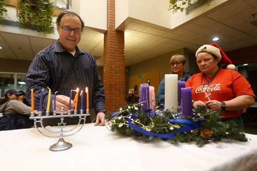 JOHN WOODS / WINNIPEG FREE PRESS
Rabbi Alan Green lights a menorah, as Lynda Trono, Community Minister and Dolores Chodachek look on, during a Christmas/Hanukah Feast which was hosted by Shaarey Zedek Synagogue and West Broadway Community Ministry at Crossways in Common Sunday, December 25, 2016.

