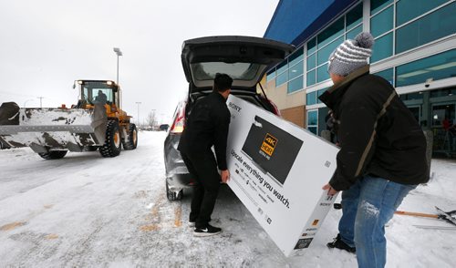 WAYNE GLOWACKI / WINNIPEG FREE PRESS

The Boxing Day blizzard didn't prevent Frances Manalo,right, from grabbing a deal on a TV at the Best Buy store on St. James St. Sales rep. Josh Ascencion gives him a hand getting it in his SUV.  Dec.26 2016