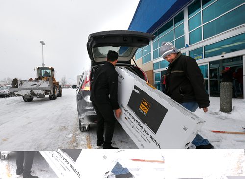 WAYNE GLOWACKI / WINNIPEG FREE PRESS

The Boxing Day blizzard didn't prevent Frances Manalo,right, from grabbing a deal on a TV at the Best Buy store on St. James St. Sales rep. Josh Ascencion gives him a hand getting it in his SUV.  Dec.26 2016