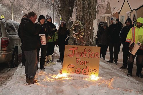 Canstar Community News Kevin Joss (left) looks at the plaque at the Vigil for Cody on Dec. 19, 2016.