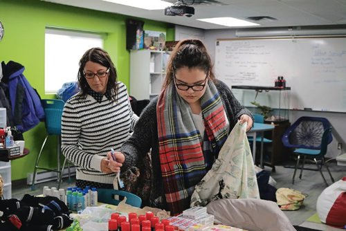 Canstar Community News Met School Principal Nancy Janelle (left) and student Hilary assemble care packages for the homeless on Dec. 19, 2016.