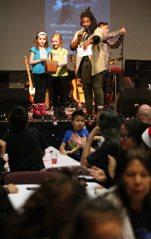 JASON HALSTEAD / WINNIPEG FREE PRESS

Emcee Ify Chiwetelu, host of Now or Never on CBC Radio One, gets a little help on stage from Gillian Coulter, 9, (left) and Ilsa Buchholz, 7, at the West End Cultural Centres annual holiday dinner and concert on Dec. 22, 2016.  (See Social Page)