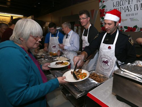 JASON HALSTEAD / WINNIPEG FREE PRESS

Andrew Swan, MLA for Minto and Winnipeg Police Service Cst. Terrence Small serve up food to Barbara McKenny (left) at the 11th annual X-Cues Café, West End BIZ, Sorrentos, Sons of Italy Christmas Eve Feast at X-Cues Café on Sargent Avenue in the West End on Dec. 24, 2016. (See Social Page)