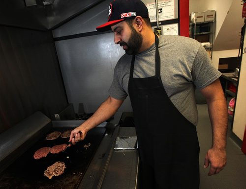 PHIL HOSSACK / WINNIPEG FREE PRESS -  Proprietor Andy Kostis flips fresh burgers on the grill at "The Burger Place" on Portage ave. See Dave Sanderson's story. ....January 5 ,2017