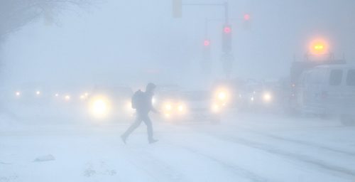 MIKE DEAL / WINNIPEG FREE PRESS
A pedestrian dashes across Portage Avenue at Maryland Street Thursday morning as high winds cause blowing snow. 
170112
Thursday, January 12, 2017