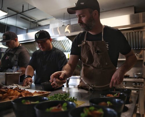 MIKE DEAL / WINNIPEG FREE PRESS

Chef Ben Kramer (right) prepares a dish during the Winnipeg Free Press Sunday Brunch Collective at the Kitchen Sync. 
This course is his take on Fish and Chips; a celery root purée, halibut, garlic cream, vegetable chips, and pea leaves. 

170115
Sunday, January 15, 2017