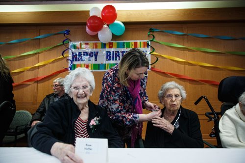 MIKE DEAL / WINNIPEG FREE PRESS
Rose Hoffer (left), 100, laughs as Faye Paker (right), 100, gets a corsage from staff member Sara prior to the start of the Centenarian Celebration at the Saul & Claribel Simkin Centre where ten women will be celebrated for their birthdays, all of them at least 100 years old.
170123 - Monday, January 23, 2017.