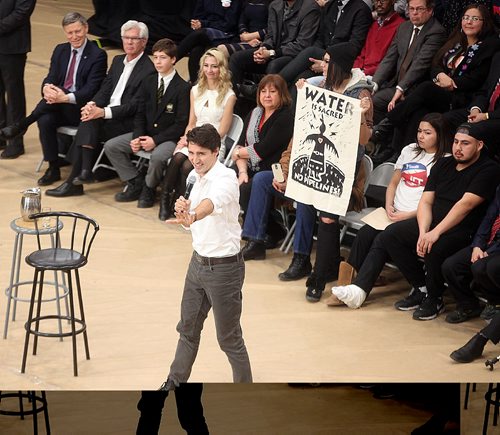 PHIL HOSSACK / WINNIPEG FREE PRESS -  Prime Minister Justin Trudeau debates hecklers in the Town Hall crowd at the University of Winnipeg Thursday as people seated behind him unfurl banners. See story.  ....January 26, 2017