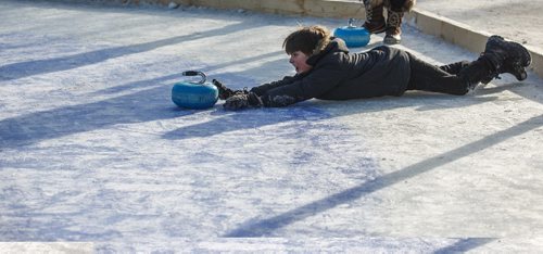 MIKE DEAL / WINNIPEG FREE PRESS
Felix Salkeld, 9, throws a curling rock while playing Croki-curl with his family at The Forks Sunday afternoon.
For 49.8 piece on Crokinole.
170129 - Sunday, January 29, 2017.