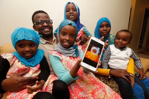 JOHN WOODS / WINNIPEG FREE PRESS
Liibaan and Sahra Ali with their children, from left, Bayaan, 3, Bushra, 7, Bahja, 5 ,and Bashar, 2 hold a photo of their grandmother Norta in their home Monday, January 30, 2017. Liibaan's mother is a Somalia-born US citizen who lives in Phoenix and was planning to come to visit her grandkids Feb. 10 but cancelled her plans since Trumps executive order was issued. Shes scared if she gets here she wont be allowed back into the U.S..
