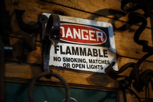 MIKE DEAL / WINNIPEG FREE PRESS
Blacksmith Matt Jenkins owner of Cloverdale Forge.
A sign warns against open flame close to the gas fired forge.
170131 - Tuesday, January 31, 2017.