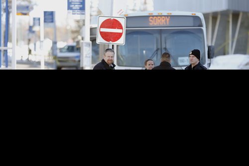 Homicide detectives and officers investigate at the scene of a fatal stabbing of a bus driver at the University of Manitoba in Winnipeg, Tuesday, February 14, 2017.  THE CANADIAN PRESS/John Woods