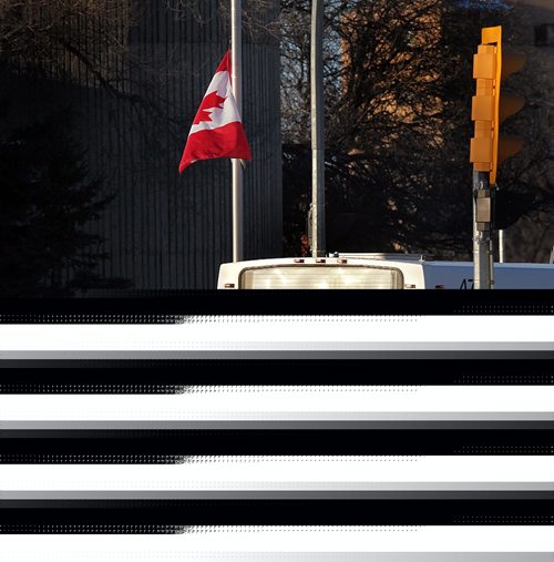PHIL HOSSACK / WINNIPEG FREE PRESS  -   A city transit bus pulls into the city garage and headquarters on Osborne street south past a flag at half mast mourning the loss of a driver after a deadly assault.   See story.  - February 13, 2017
