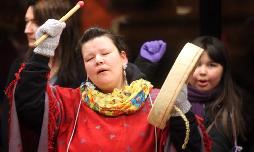 PHIL HOSSACK / WINNIPEG FREE PRESS  - Raising her drum high, a drummer sings taking part in a  "Women's Memorial March of Manitoba as it  makes it's way around the U of W Tuesday evening in honor of Murdered and Missing Indigineous Women before unveiling a "We Care Quilt".   See story.  - February 13, 2017
