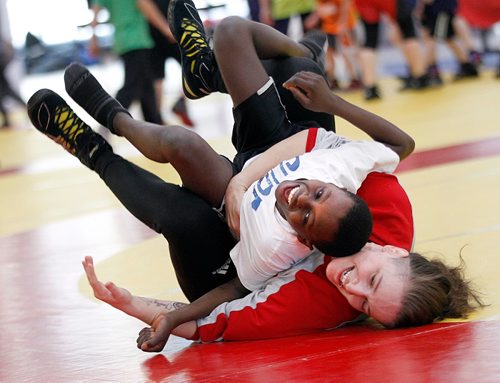 PHIL HOSSACK / WINNIPEG FREE PRESS  -  Mohamed Sesay takes a tumble with Wesmen Assistant Head Coach & Olympian Leah Ferguson. the 14yr old from Sierra Leon and other kids were taking part in a wrestling workshop at U of W Thursday. University of Winnipeg Wesmen play host to the 2017 U Sport National Wrestling Championships this weekend, See Jason Bell story.  - February 23, 2017