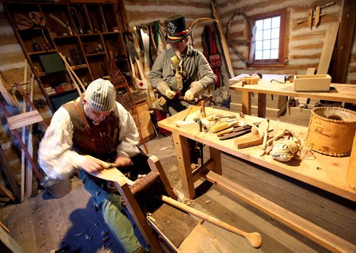 PHIL HOSSACK / WINNIPEG FREE PRESS  - Re-enacting Fort Gibralter's Shipwright Mark Blieske works carving a canoe paddle out of cherry wood while Sr Clerk Seraphian Lemarre watches his progress Friday evening as Festival du Voyageur enter's the second weekend.  - February 24, 2017
