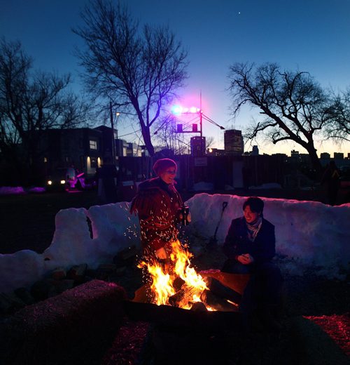 PHIL HOSSACK / WINNIPEG FREE PRESS  - Linda Leclerc (left) and Jonathan Laurent share a little warmth and laughter around a fire at Whittier Park Friday evening as Festival du Voyageur enter's the second weekend.  - February 24, 2017