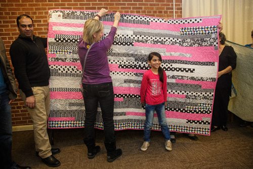 MIKE DEAL / WINNIPEG FREE PRESS
With her dad Khaled Ali (left), Zainab, 8, thanks Heather Glaser (centre) the person who made the quilt that was given to her. Heather is a member of The Riverview Quilters, a group of quilters who decided a year ago to make a quilt for each of thirteen Syrian refugees (three families) sponsored by the South Osborne Syrian Refugee Initiative. During a ceremony at the Churchill Park United Church everyone was presented with their handmade quilts.
170305 - Sunday, March 05, 2017.
