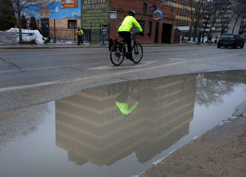 WAYNE GLOWACKI / WINNIPEG FREE PRESS

A cyclist commuting down Fort St. reflects in a puddle on a foggy Monday morning. More rain and snow is in the forecast. March 6   2017