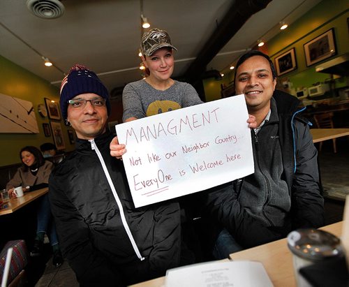 49.8 FEATURE :  
PHIL HOSSACK / WINNIPEG FREE PRESS  - Falafel Place waitress Alyssa Hendler brandishes a banner before hanging it in the restraunt window. Shahadat Hossain (left) and Subir Barman relax at Ami Hassan's Falafel Place Restraunt Wednesday morning. Randy Turner / Melissa Martin story.  -  March 3, 2017