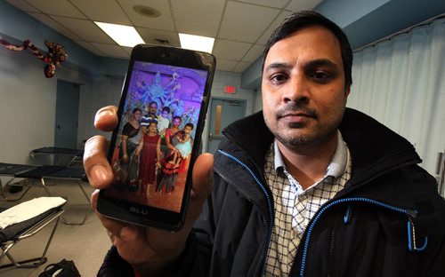 49.8 FEATURE :  
PHIL HOSSACK / WINNIPEG FREE PRESS  - Killing time in his Salvation Army overflow shelter, Subir Barman uses his cell phone to show a photo of himself posing with his family back home in Bangladesh. -  March 3, 2017