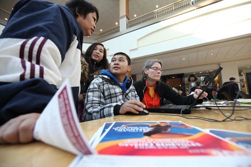RUTH BONNEVILLE / WINNIPEG FREE PRESS

Canada Summer Games volunteer Joan Griffith Parker assists Matthew Mendoza (15yrs), to sign up to volunteer at the Canada Summer Games this summer at the recruitment station at centre court in Polo Park Saturday. 
His cousin, Ashlee Landicho (behind him) and mother, Marilyn Mendoza look over his shoulder. 
Even though Matthew is only 15yrs he can still sign up as a volunteer with parental consent. 

March 11th, 2017 
Ruth Bonneville 
Winnipeg Free Press 
