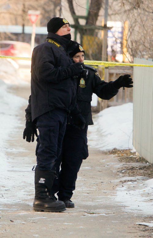 BORIS MINKEVICH / WINNIPEG FREE PRESS
Police and Forensic Unit members look for clues near the crime scene in the 200 block of Spence Street this morning. March 13, 2017 170313