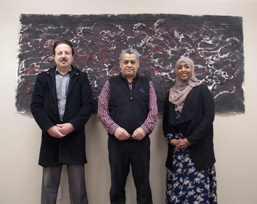 Canstar Community News Auday Ab Redah, an Arabic speaking settlement worker, and Nadim Ado, a Syrian refugee and artist who has found a home in Elmwood, and Edil Gure, neighbourhood immigrant settlement worker for Elmwood, stand in front of one of Ado's paintings, which depicts the migration of Syrian refugees through Macedonia. (SHELDON BIRNIE/CANSTAR/THE HERALD)