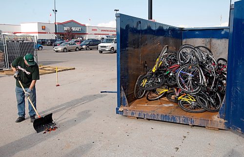 BORIS MINKEVICH / WINNIPEG FREE PRESS  080930 A worker cleans up the mess after Walmart desposes of bikes that were returned to the store. He said that they were defective and could not be safely sold or given away to the public.