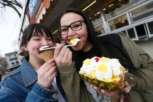 JOHN WOODS / WINNIPEG FREE PRESS Faith Sobotkiewicz (L) and Lyric Lupichuk chow down on a Saltzberg and Sleeping Beauty as they get the first taste of summer at the Bridge Drive-In (BDI) Sunday, March 19, 2017. BDI opened today for the season.