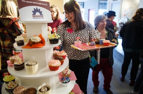 MIKE DEAL / WINNIPEG FREE PRESS
Ann Rivera, member of MAWA, artist and volunteer at the event, set out fresh cupcakes.
A packed house of art lovers mingle during MAWAs annual Over the Top art auction and cupcake party at their location on Main Street Sunday afternoon.
170326 - Sunday, March 26, 2017.