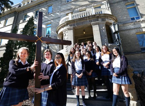 WAYNE GLOWACKI / WINNIPEG FREE PRESS
Faith Page.  In the foreground from left, Deirdre Beaumont, Marysa Fosty and Alliah Ramirez with fellow students and staff of St. Mary's Academy with large cross used on Good Friday.   Brenda Suderman story April 3     2017