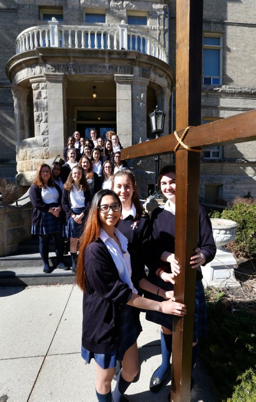 WAYNE GLOWACKI / WINNIPEG FREE PRESS
Faith Page . With the cross from left is Alliah Ramirez, Deirdre Beaumont and Marysa Fosty with fellow students and staff of St. Mary's Academy. The large cross will be used on Good Friday.   Brenda Suderman story April 3     2017