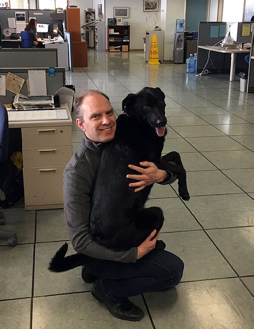 GORDON SINCLAIR JR / WINNIPEG FREE PRESS
Dash the black lab gets a hug from owner David Fuller in the newsroom.
170328 - Tuesday, March 28, 2017.