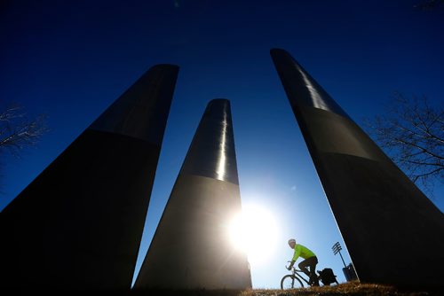 JOHN WOODS / WINNIPEG FREE PRESS
A cyclist passes an airplane sculpture on Waterfront Drive in Winnipeg Monday, April 3, 2017. Temperature was to hit 14 degrees today which saw people get out and enjoy the warm conditions.