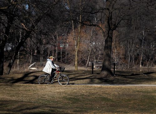 PHIL HOSSACK / WINNIPEG FREE PRESS  -  Warm temperatures and sunny skies opened up the possibility of spring Wednesday as a cyclist pedals her way along the Assinaboine Park trails.  -  April 4, 2017