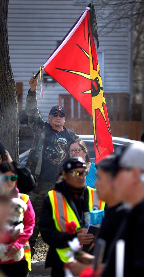 PHIL HOSSACK / WINNIPEG FREE PRESS  - A member of the Urban Warrior Alliance waves the American Indain Movement flag near the scene of Christine Wood's murder on Burrows ave during a vigil and march to Thunderbird House Wednesday. ....See Carol's story.  -  April 12, 2017