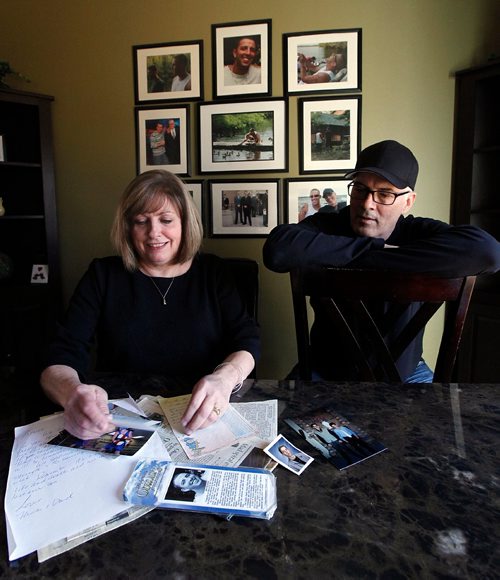 PHIL HOSSACK / WINNIPEG FREE PRESS  -  Scott and Anne Oake sift through a box of their son Bruce's memoribilia. The wall behind them is covered with portraits featureing Bruce who died of an overdoese. See Randy Turner's story. -  April 13, 2017