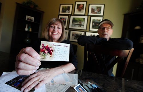 PHIL HOSSACK / WINNIPEG FREE PRESS  -   Anne Oake shows off a mother's day note from her son Bruce as she and her husband Scott sift through a box of their son Bruce's memoribilia. The wall behind them is covered with portraits featureing Bruce who died of an overdoese. See Randy Turner's story. -  April 13, 2017